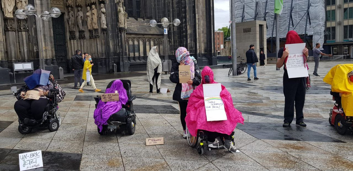 Stiller Protest mit Decken über dem Kopf und Protestschildern gegen das IPReG vor dem Kölner Dom.