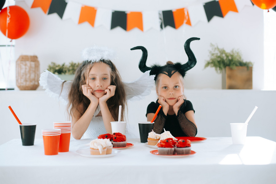 2 Kinder verkleidet als Engelchen und Teufelchen