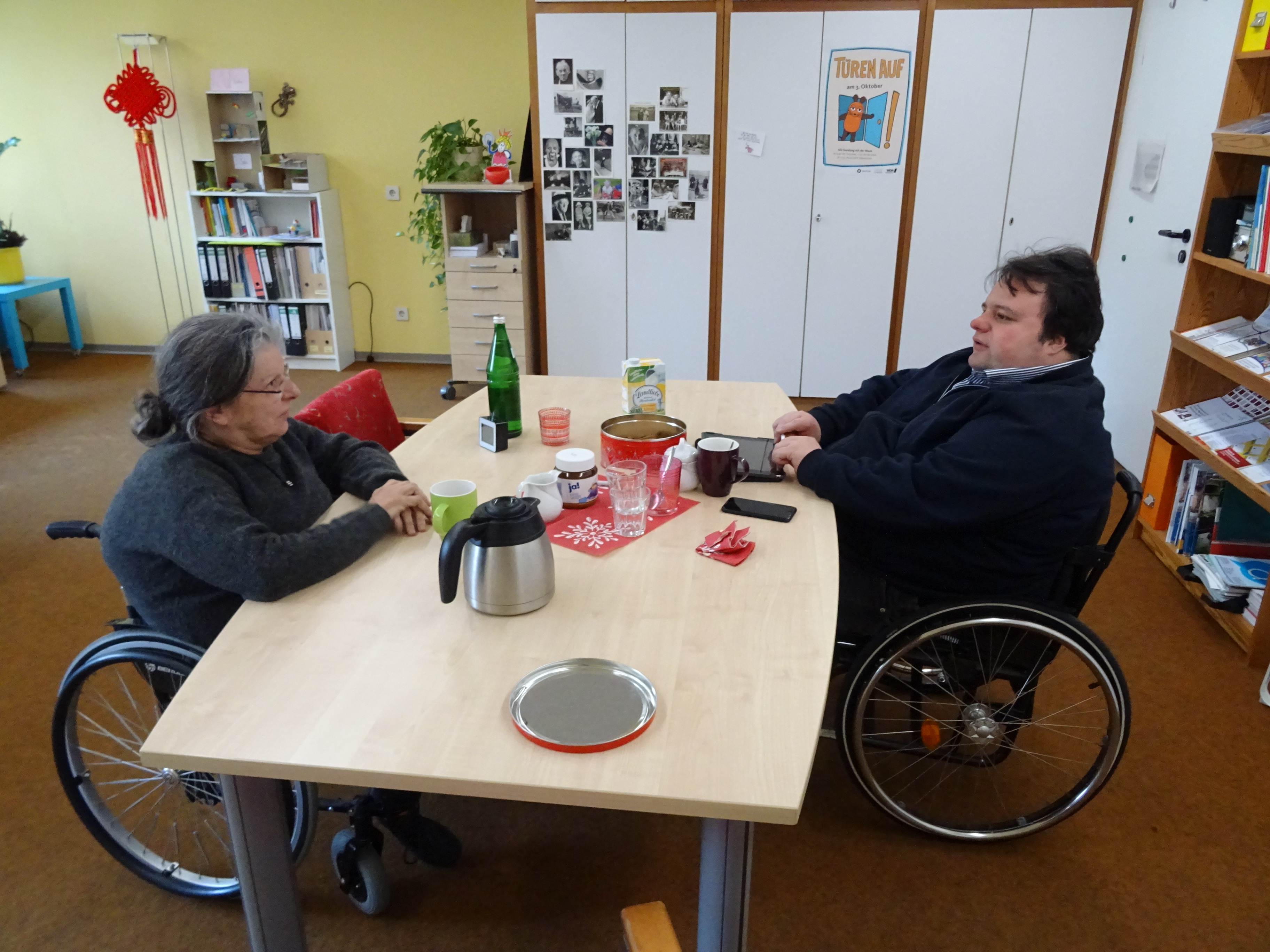Frau Reomberg-Hoffmann und Herr Thomas sitzen an einem Tisch und diskutieren.