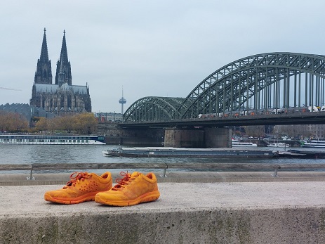orangenes Schuhpaar vor Kölner Panorama