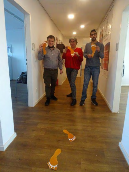 Mitarbeiter*innen des KSL Düsseldorf mit orangenen Fußabdrücken Nr1