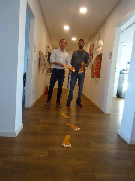 Mitarbeiter*innen des KSL Düsseldorf mit orangenen Fußabdrücken Nr3
