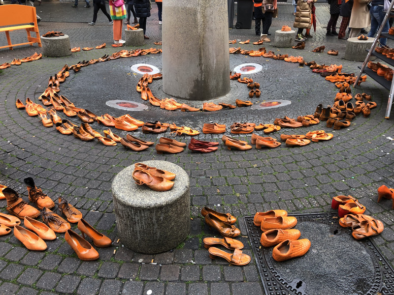 Viele orangene Schuhe, zu ineinander liegenden Kreisen aufgestellt.