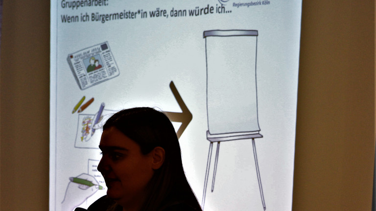 Das Bild zeigt eine Teilnehmerin vor einer Präsentation.