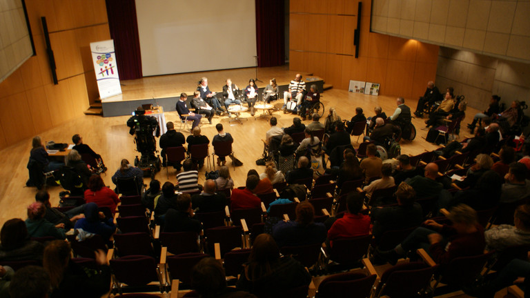 Das Bild zeigt die Podiumsdiskussion auf der Bühne.