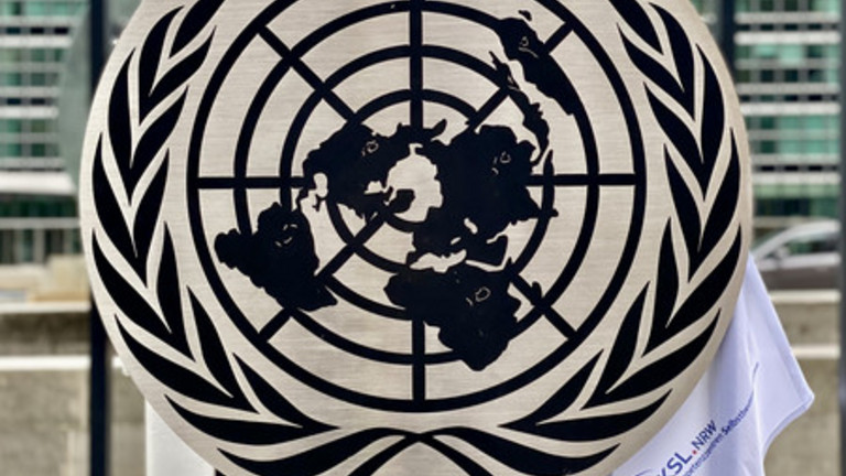 Ein Stück Stoff mit dem KSLNRW-Logo klemmt am UN-Wappen fest.