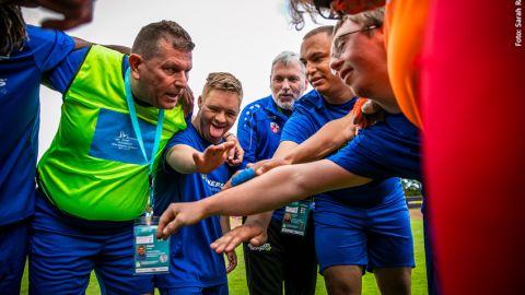 Eine Gruppe Sportler, die auf dem Spielfeld zu einer Besprechung zusammengekommen ist