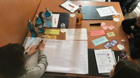 Ein Gruppentisch ist zu sehen. Darauf zu sehen sind verschiedene Materialien. 
