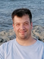 Portrait-Foto von Wolfgang Thiems, im Hintergrund Kaimauer und Wasser
