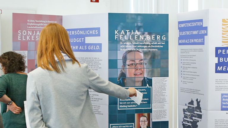Das Bild zeigt Menschen, die sich die Ausstellung ansehen.