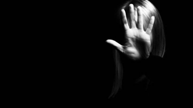 Rechts auf dem Bild ist eine Person zu sehen, die ihre Hand ausstreckt und ein Stop-Zeichen zeigt. Ihr Gesicht ist bedeckt. Schwarzer Hintergrund
