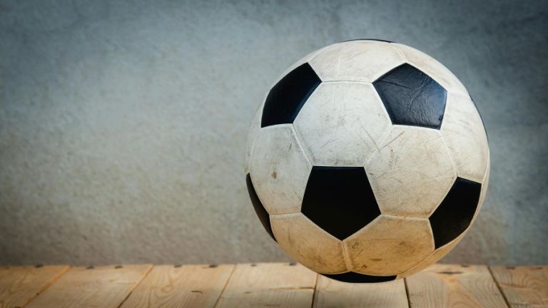 Ein Fußball schwebt über einem Holzfußboden